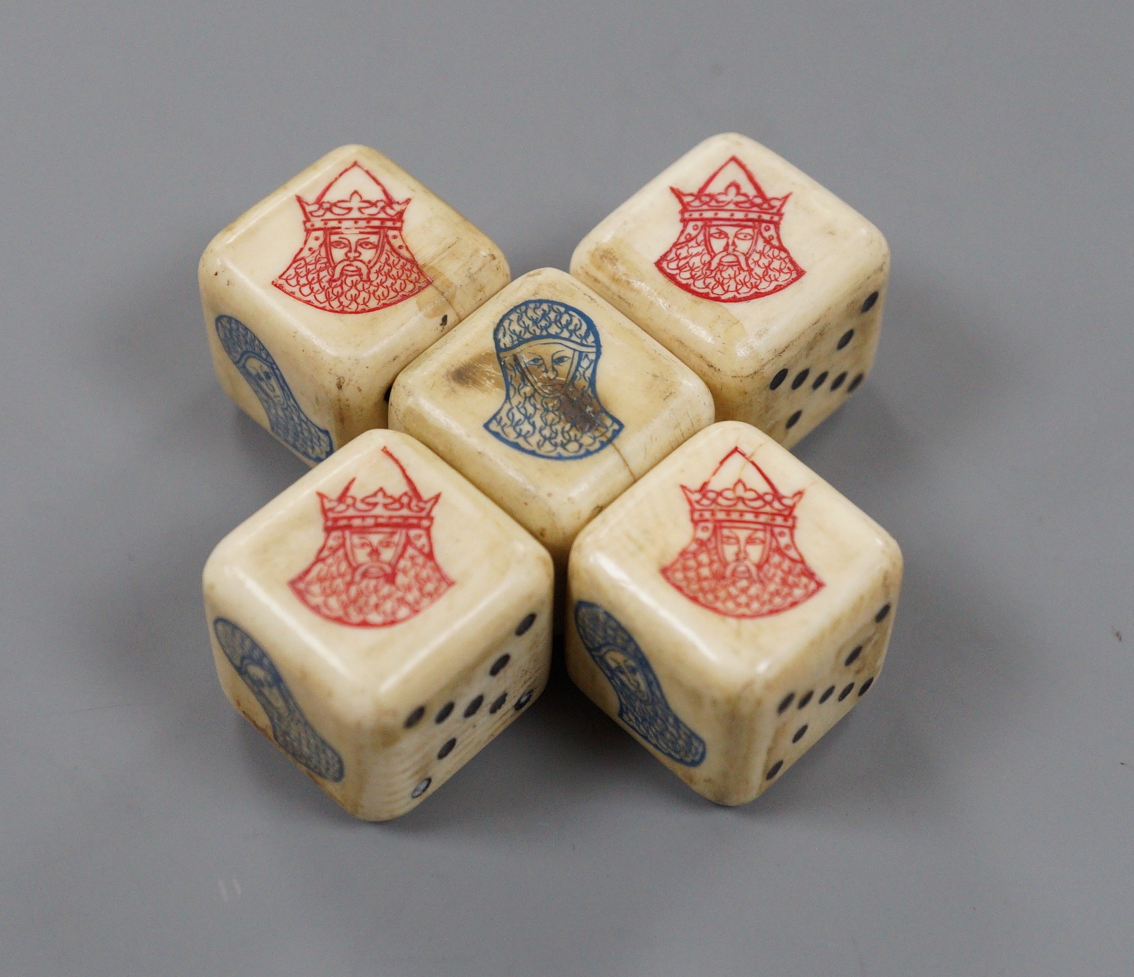 A textured white metal pyramid shaped box, the hinged panel decorated with Greek scene and containing five dice, height 62mm.